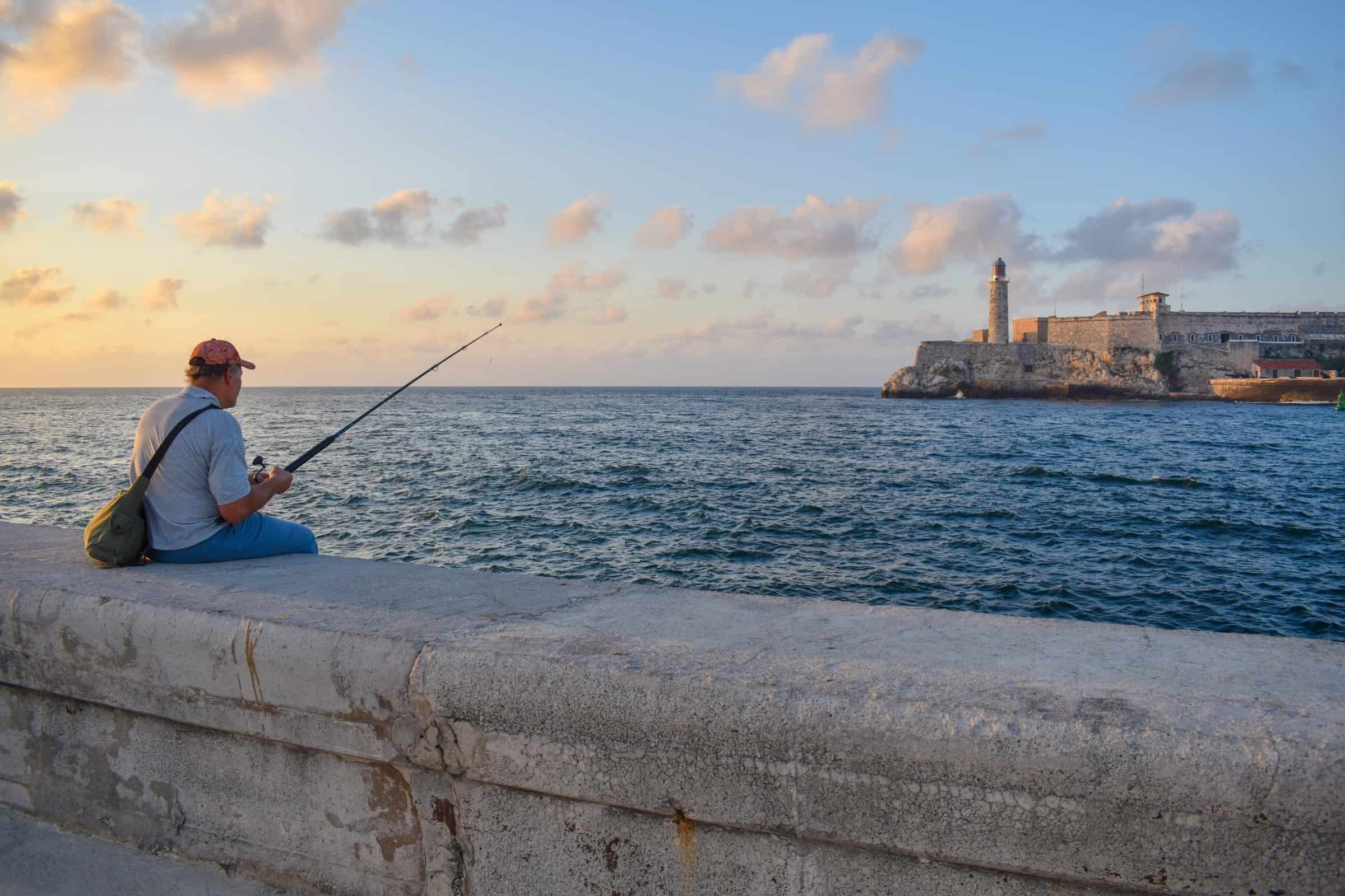 Havana's Malecon promenade with man fishing 